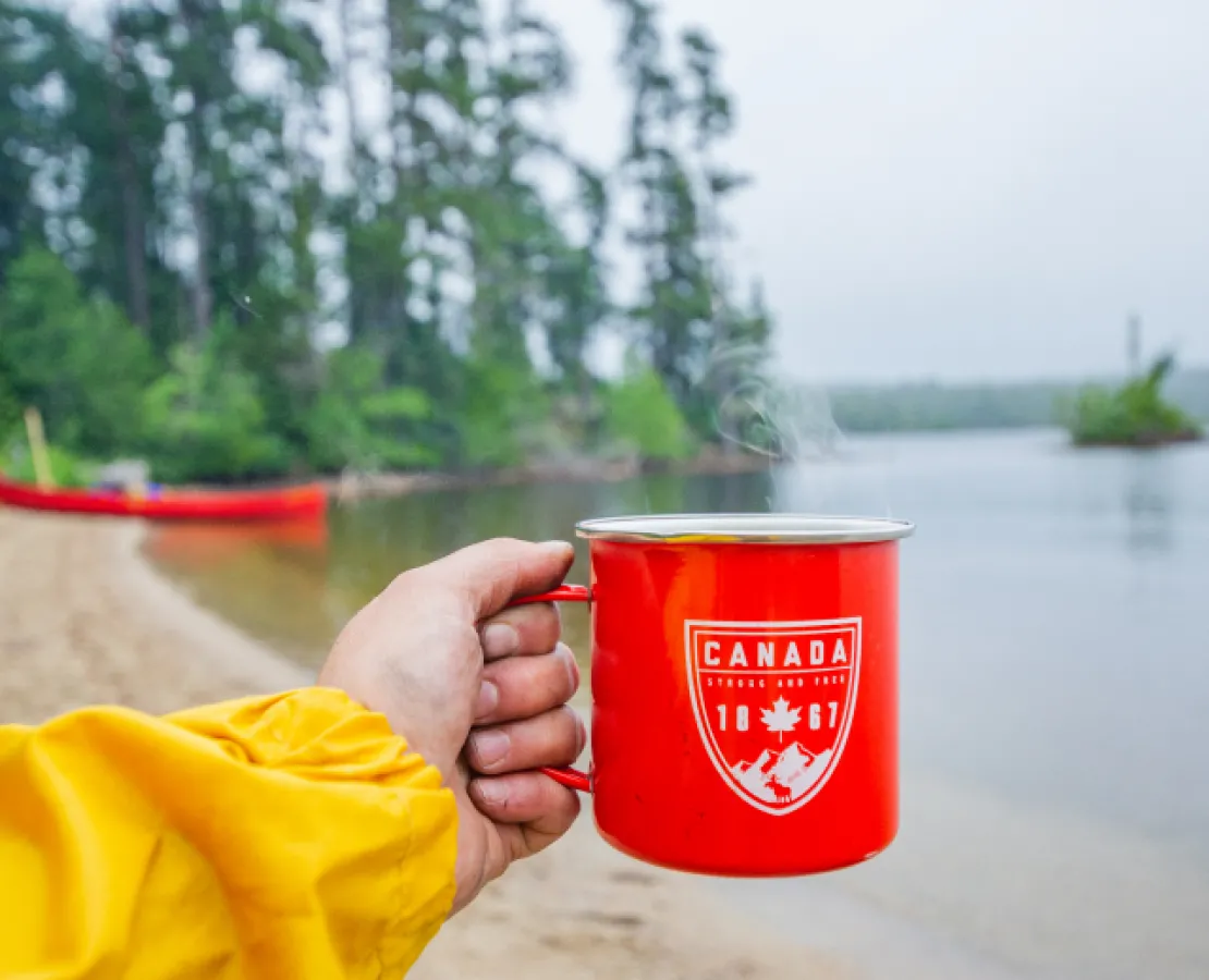 Canoe trip with red canoe and red coffee cup