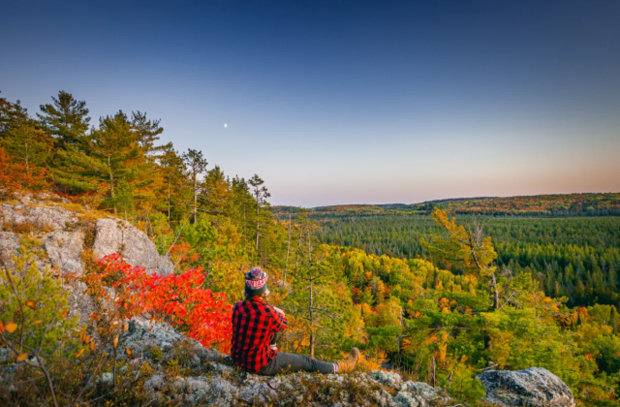 Hiking on overlook with fall foliage below